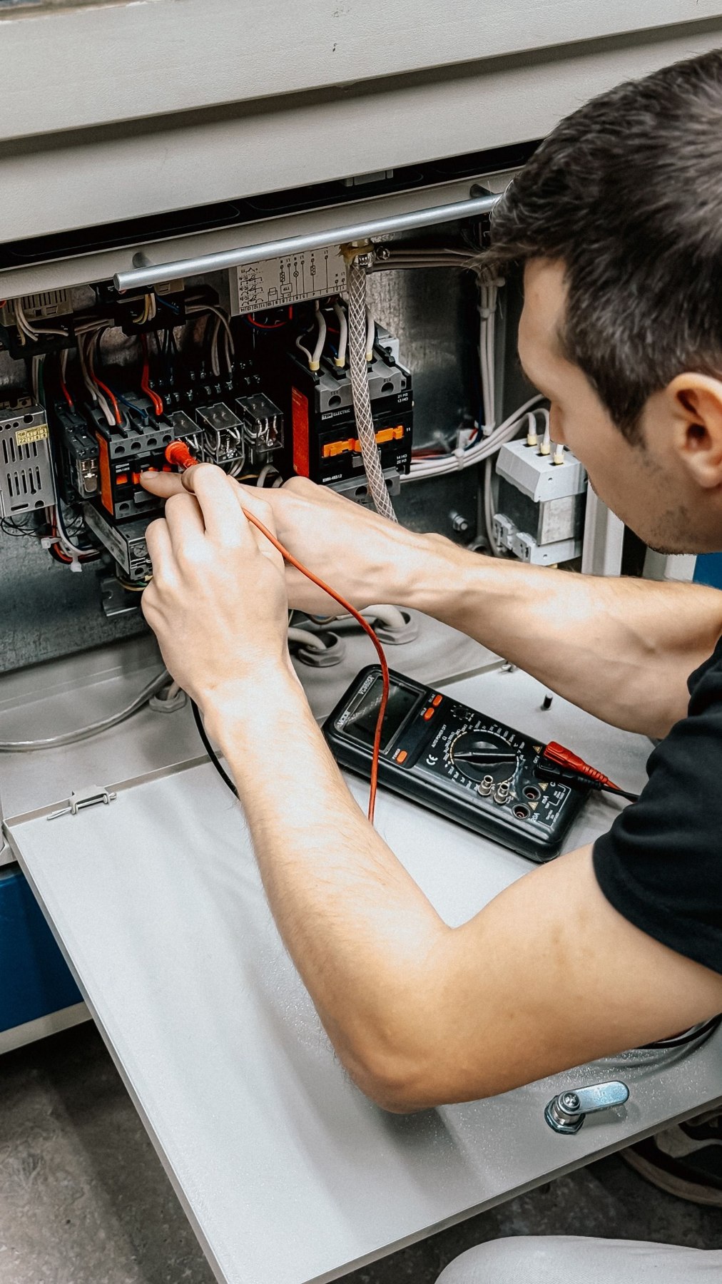 Technicien effectuant des mesures dans une armoire électrique — photo d’illustration